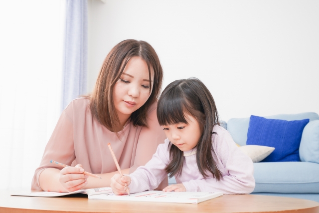 お母さんと一緒にお勉強をする小さな女の子