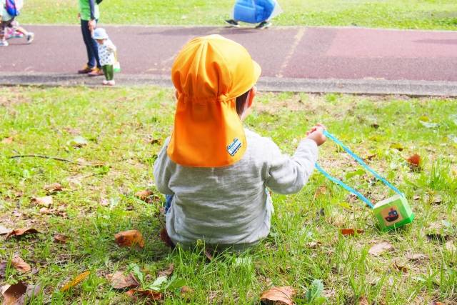 芝生の斜面に座る子供｜写真素材なら「写真AC」無料（フリー）ダウンロードOK (106304)